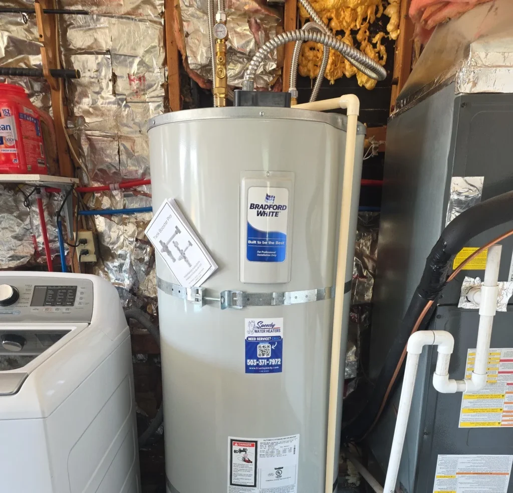 Newly installed electric water heater beside a washer