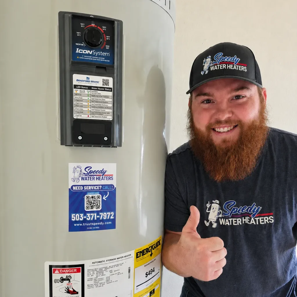 Speedy Water Heaters technician beside a newly installed electric water heater in Salem